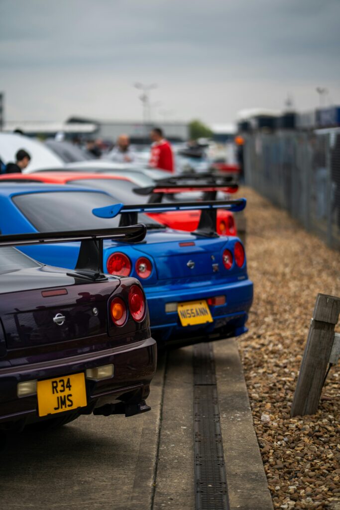 Lineup of classic Nissan sports cars showcased at an outdoor event, emphasizing vibrant design and performance.