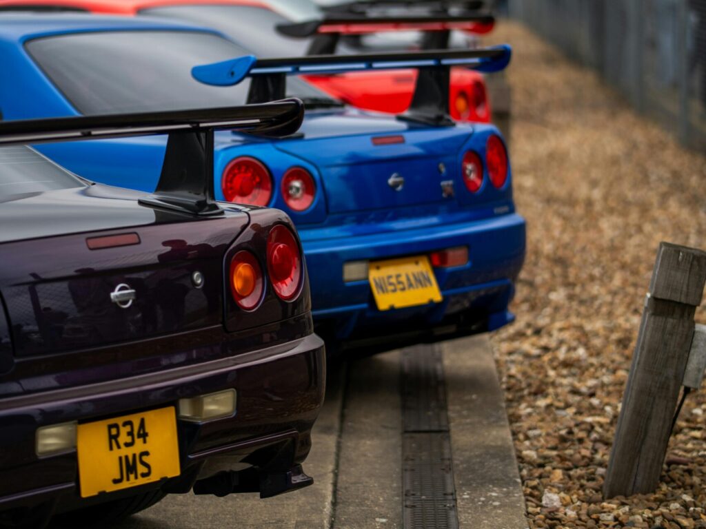 Lineup of classic Nissan sports cars showcased at an outdoor event, emphasizing vibrant design and performance.