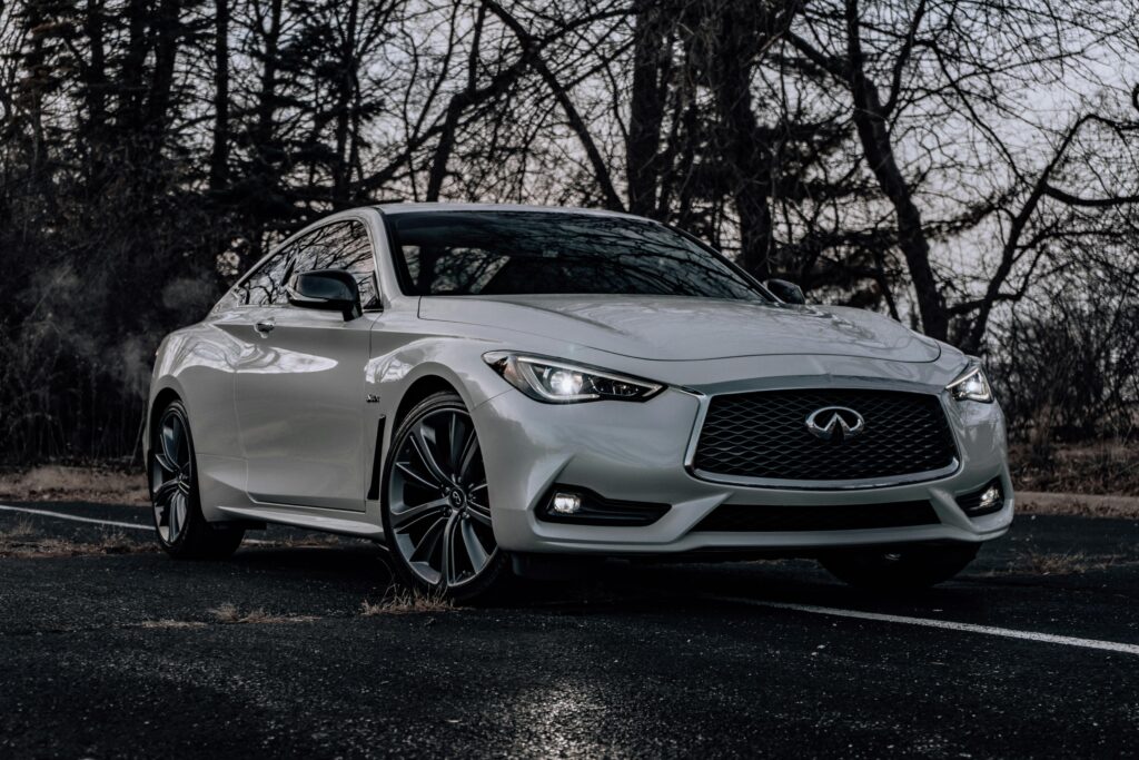 A white Infiniti coupe parked outdoors, showcasing sleek design and modern aesthetics.
